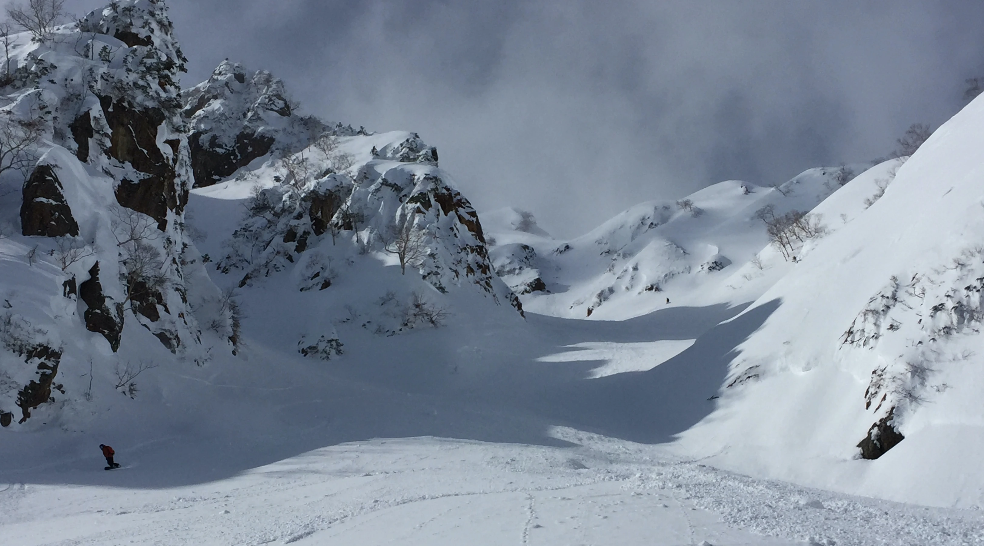 Snowboarders in Hakuba Backcountry exiting a long walled gully