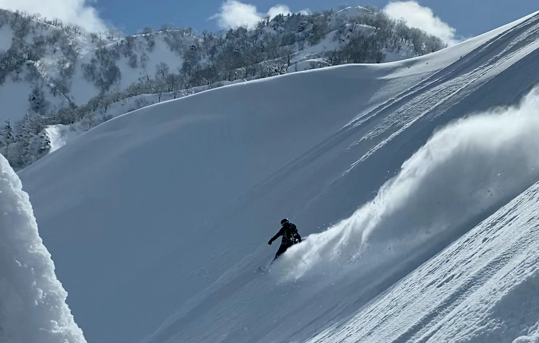 Backcountry snowboarder carving a turn in spines