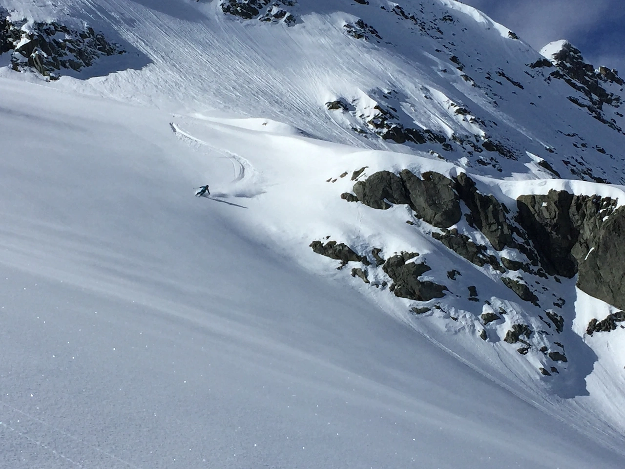 Skier ripping through dramatic alpine terrain
