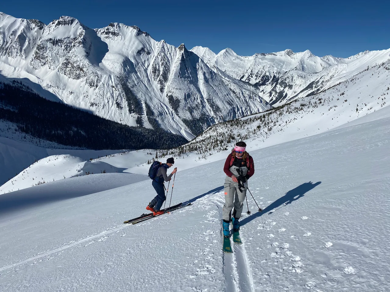 To ski tourers on a skin trail with big Mt. vista in the back ground