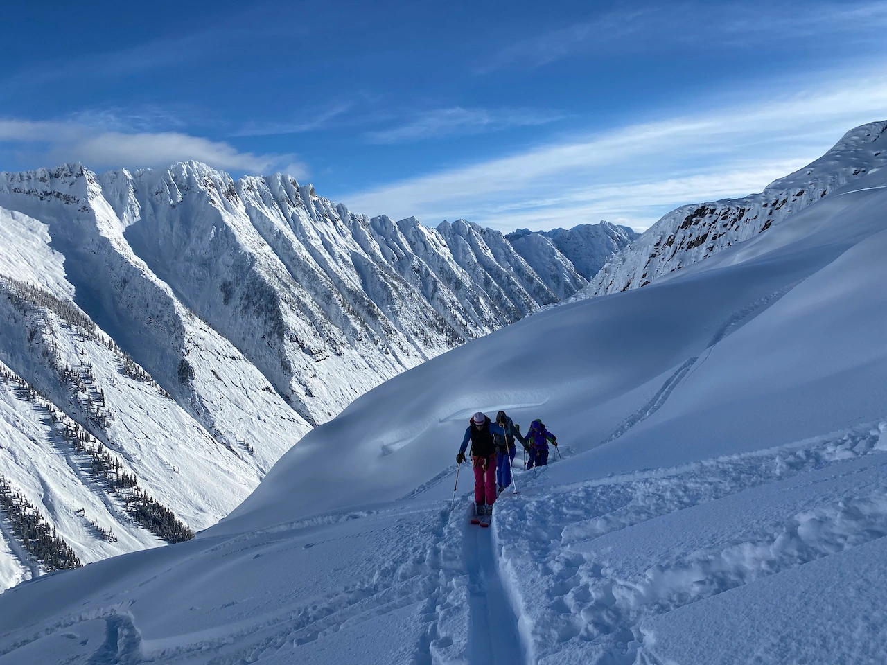 Ski tourers making there way up the skin track with interesting mountain in the back