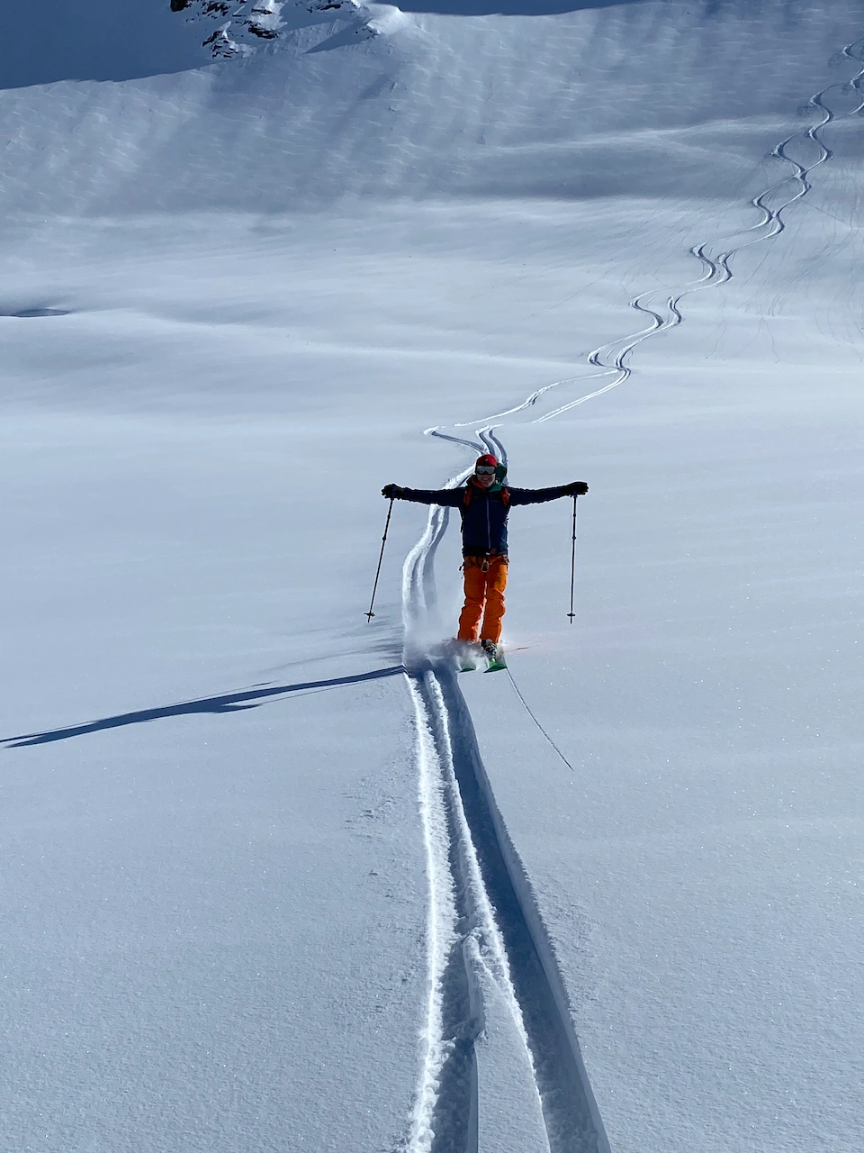 Close up of the skier with arms outstretched after a memorable descent 