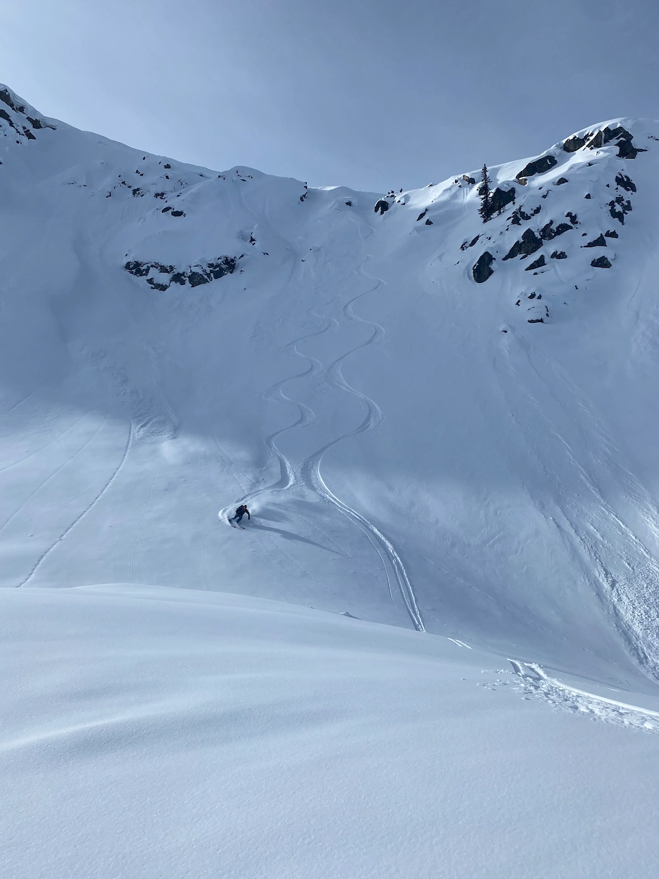 Skier descends a steep short section of a run