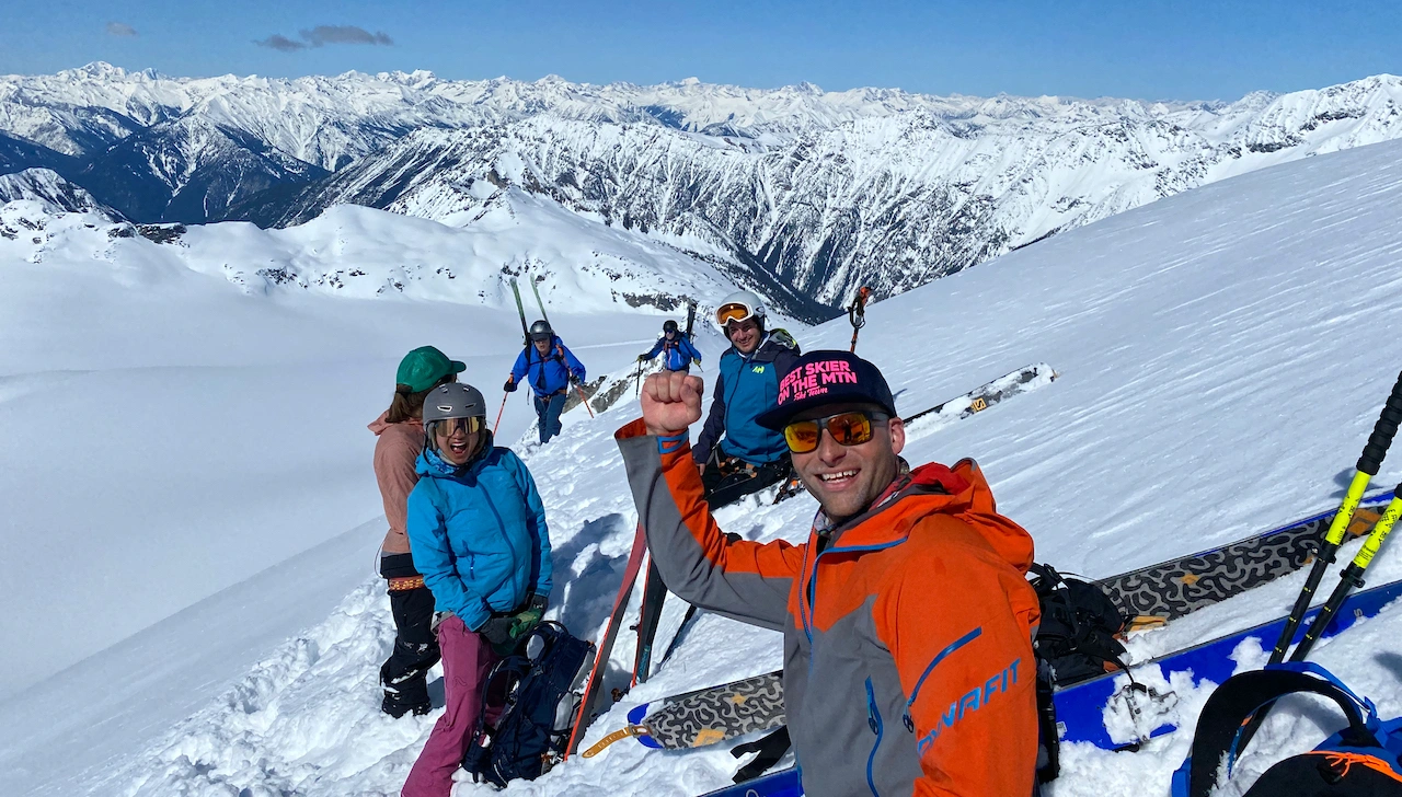 Stoke skier on the summit of 3000+ meter peak