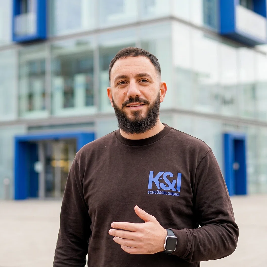 Kahlil Kassem Schlüsseldienst Experte aus Solitude Stuttgart-West, vor modernem Glasgebäude mit blauen Akzenten
