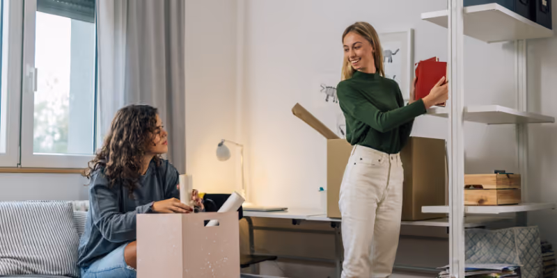 des étudiantes qui déballent leurs cartons dans leur chambre