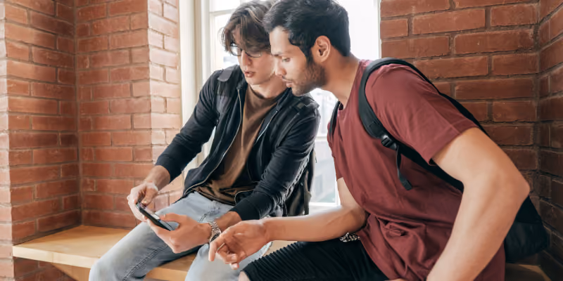 deux étudiants qui regardent leur téléphone