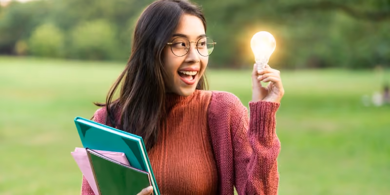 une étudiante avec une ampoule dans les mains