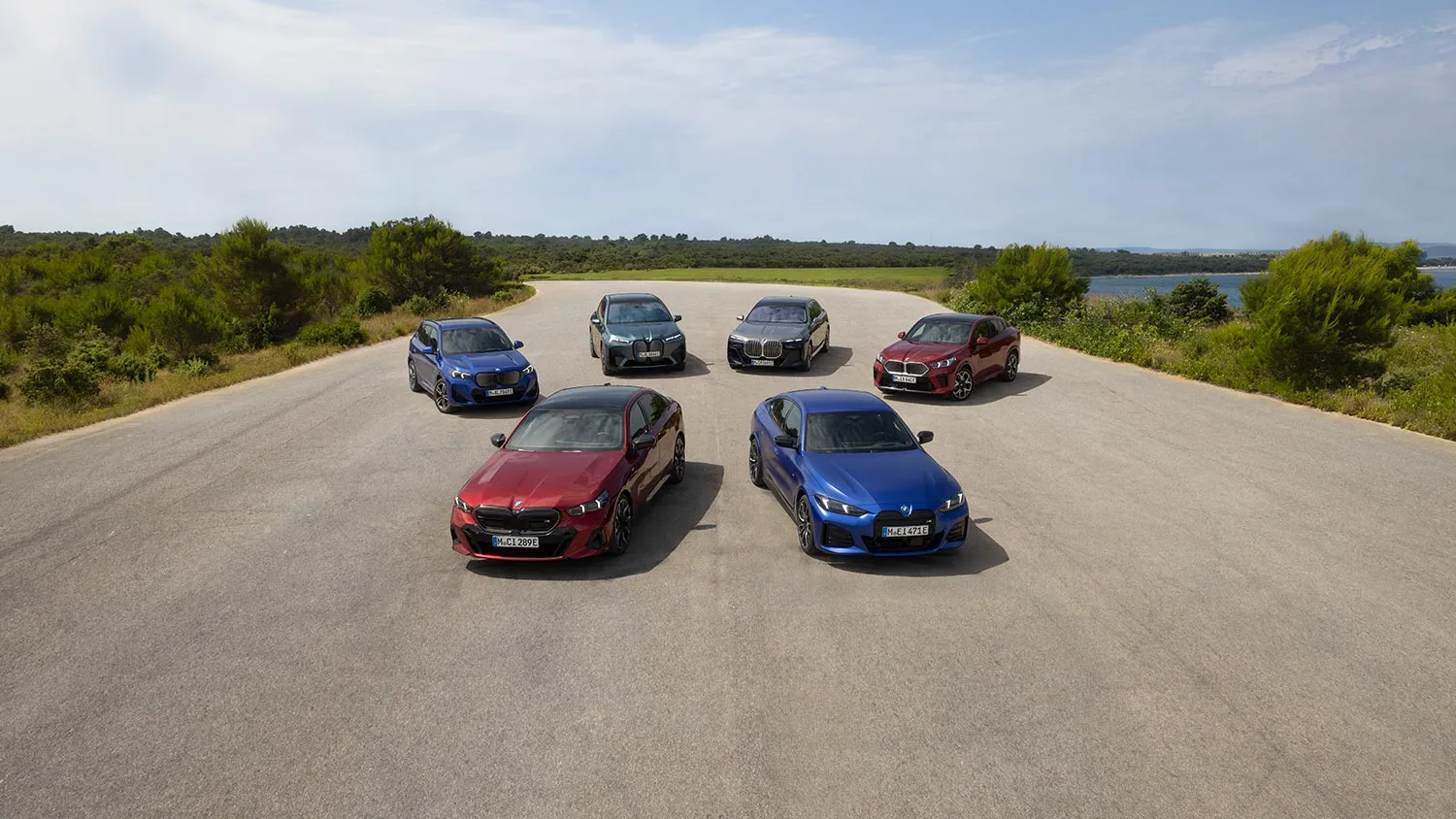 Sechs BMW-Fahrzeuge stehen nebeneinander auf einer weiten Fläche in einer sonnigen Landschaft – MOTORHEIMAT Wagner-Schwarz in Kirchseeon, Traunstein, Altenmarkt, Wasserburg und Oberhaching