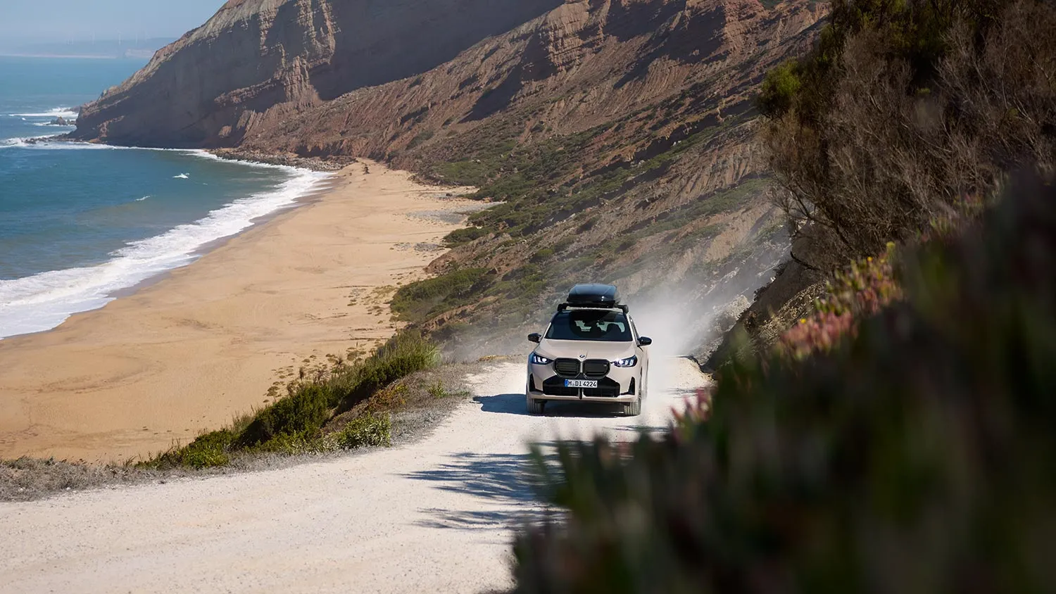BMW X3 fährt an einer Küstenstraße entlang mit Blick auf den Strand – MOTORHEIMAT Wagner-Schwarz in Kirchseeon, Traunstein, Altenmarkt, Wasserburg und Oberhaching