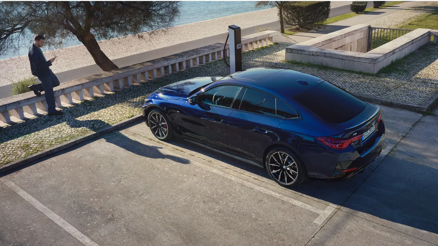 Blauer gebrauchter BMW an einer Ladesäule.