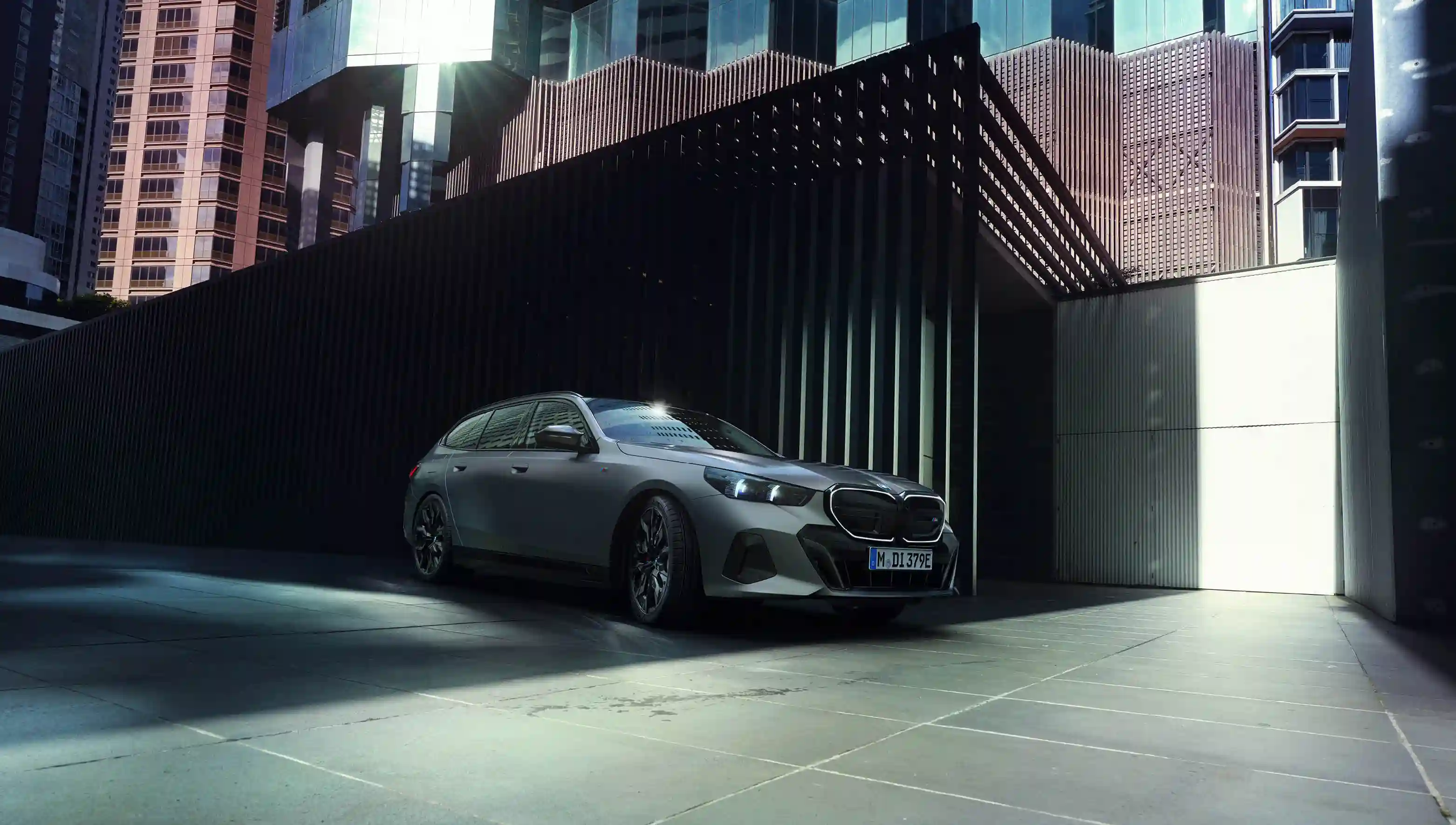 BMW i5 in einer Großstadt vor Wokenkratzer.