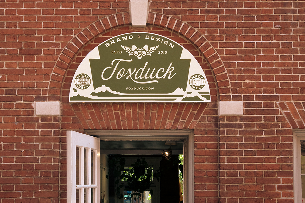 Brick exterior of Foxduck building with the gold and cream Foxduck sign above the entrance.