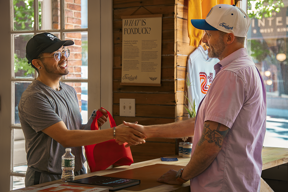 Wes and a customer shaking hands in Foxduck shop.