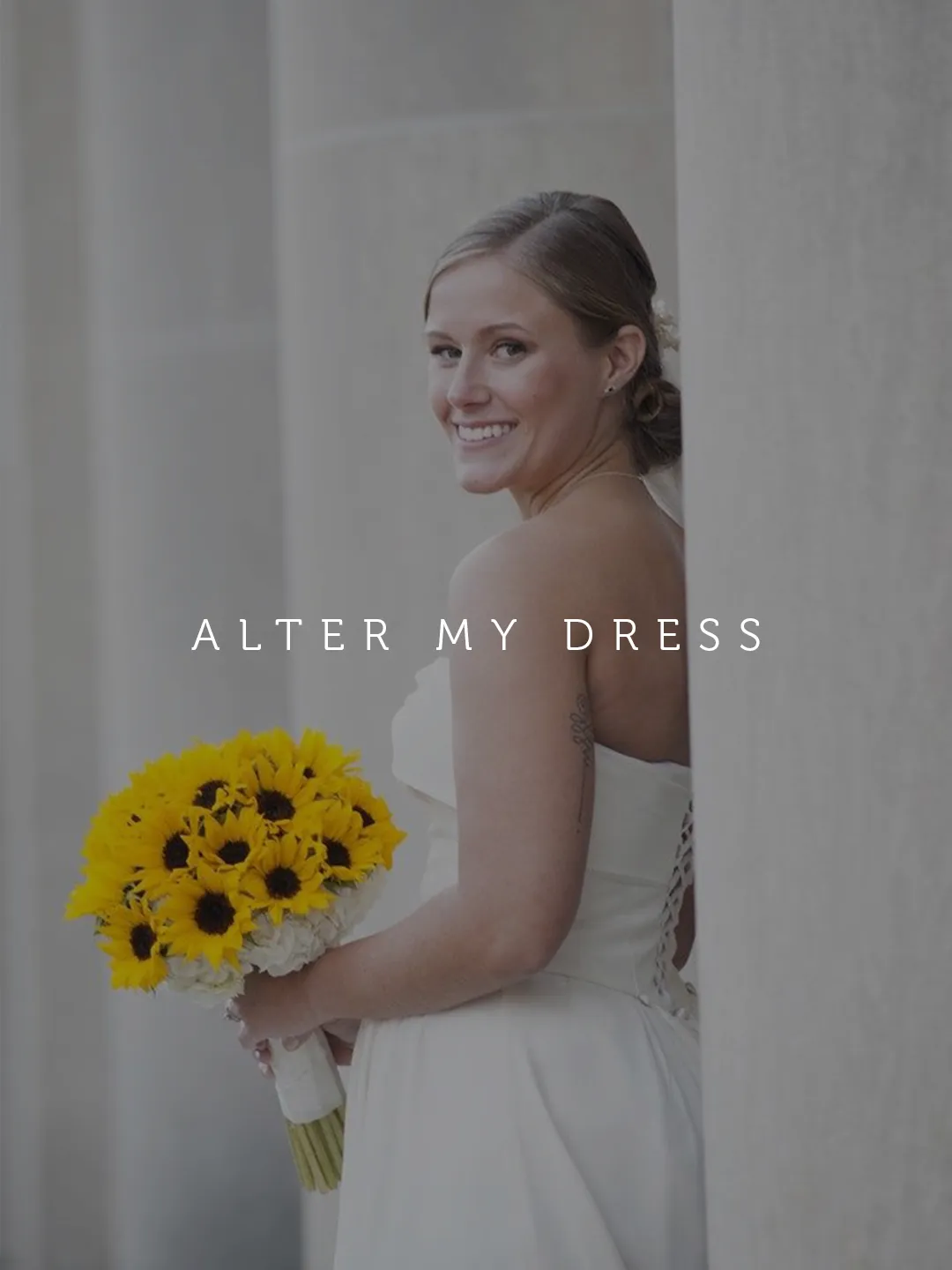 Alter My Dress Client on her wedding day in her altered wedding dress holding a bouquet of sunflowers 