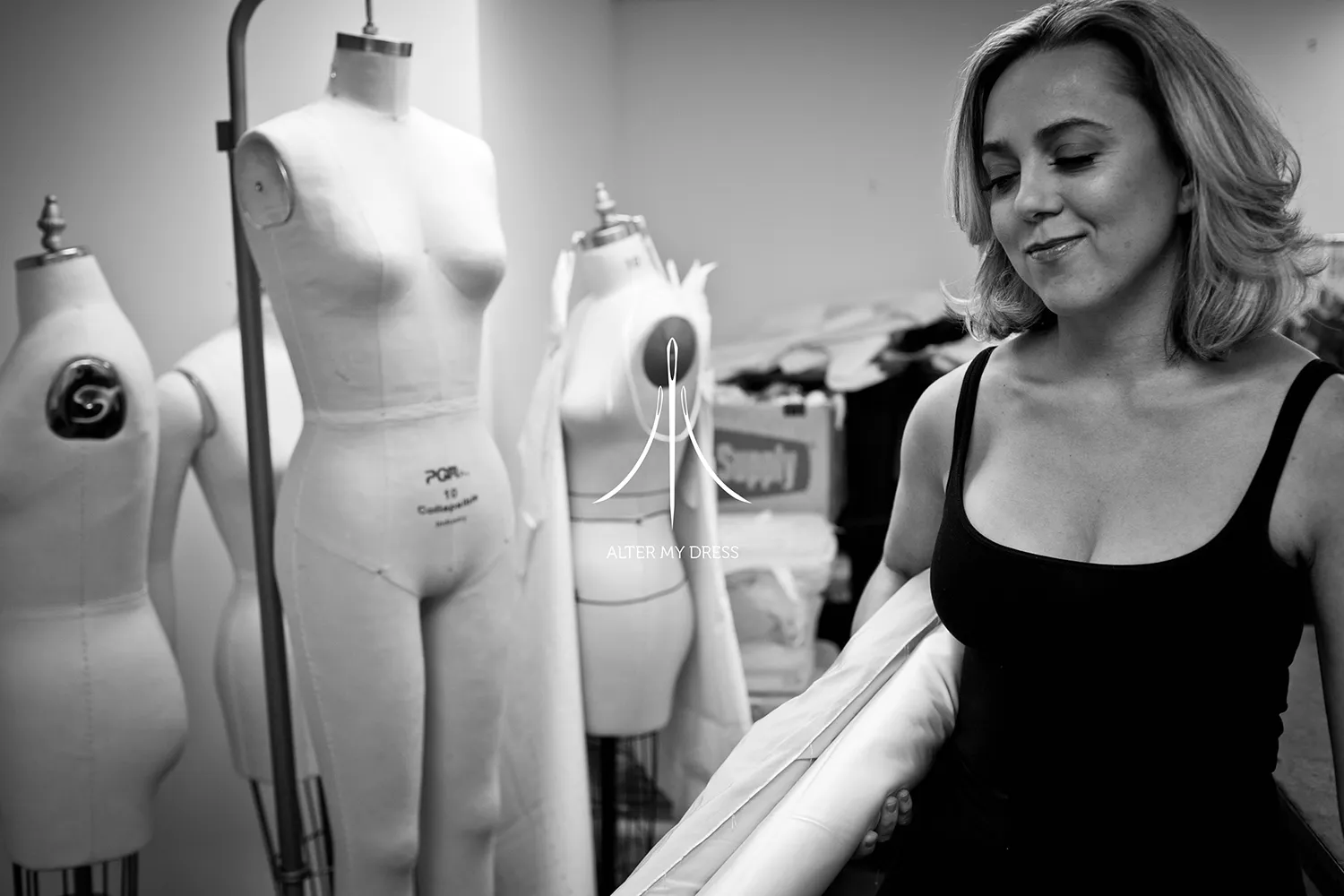 Alter My Dress logo on black and white background image of lead designer Priscilla handling materials for wedding dress alterations