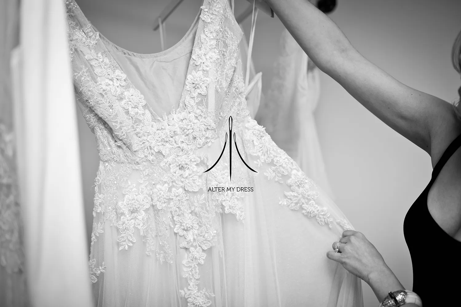 Alter My Dress logo on black and white background image of a wedding dress alterations job