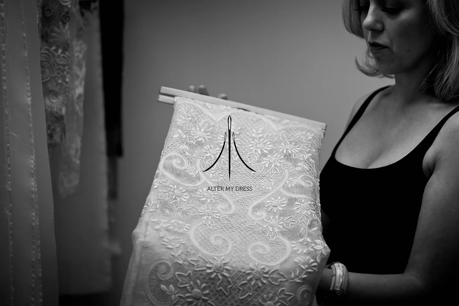 Woman examining a piece of lace fabric with floral patterns.