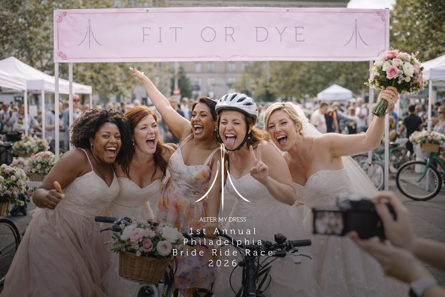 Five joyful women, four in wedding dresses and one in a floral dress, posing with bicycles under a pink 'FIT OR DYE' banner at the 1st Annual Philadelphia Bride Ride Race 2026.