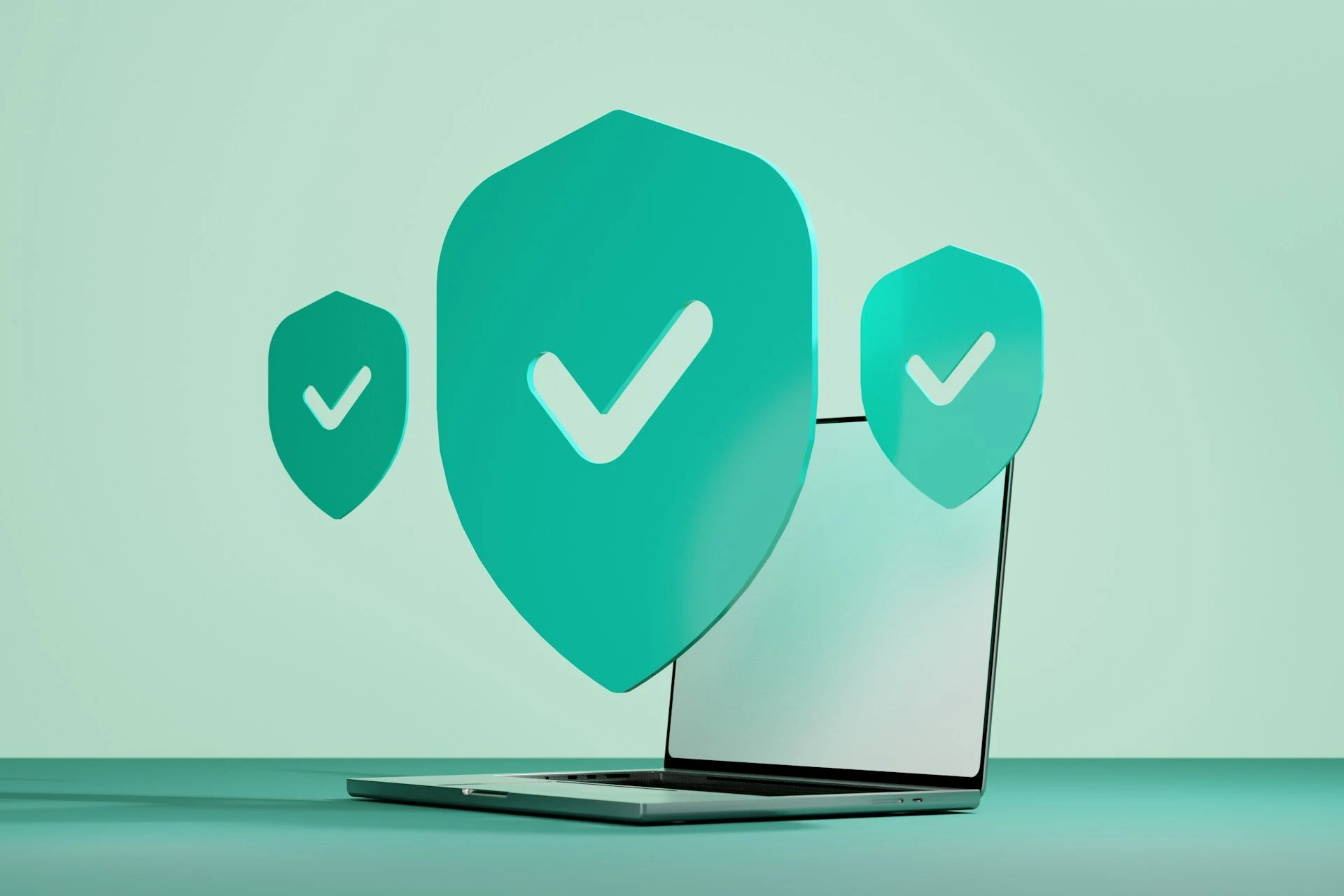 Drei Schildsymbole mit Haken schweben über einem Laptop