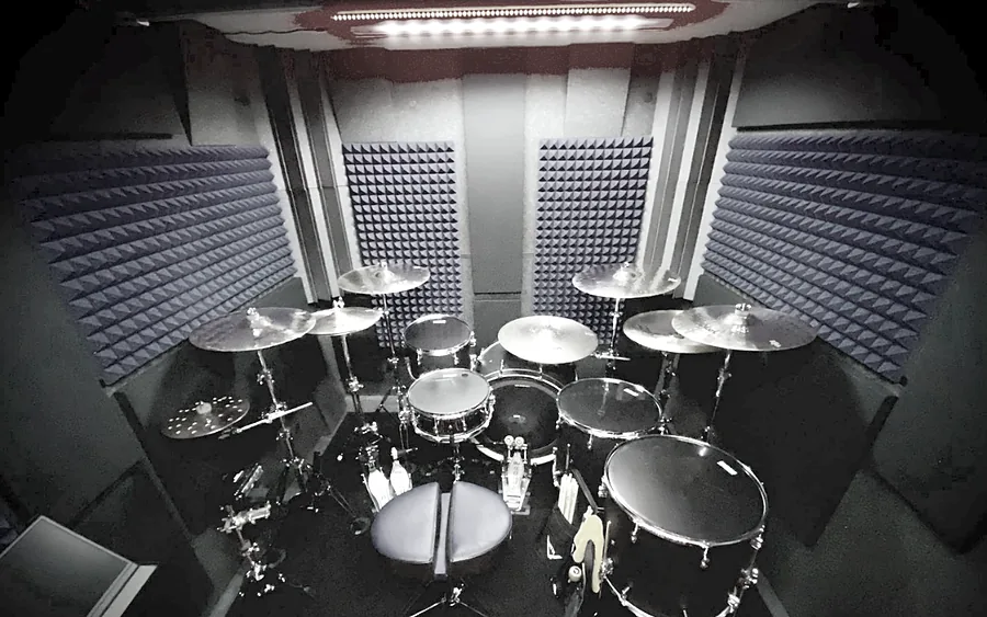 A full drum kit set up inside a WhisperRoom drum booth lined with acoustic foam, seen from above