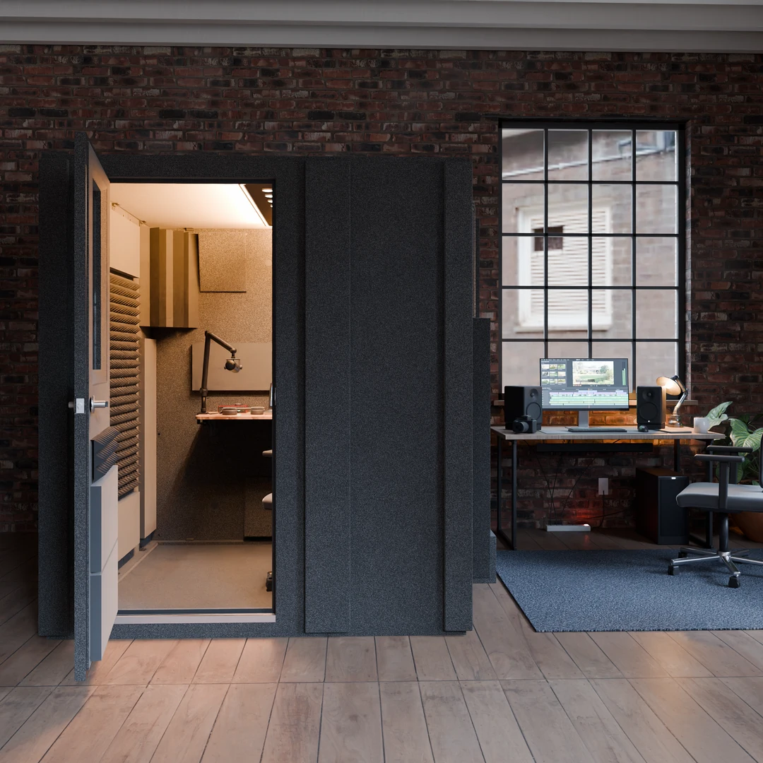 Creator Basic podcast booth in a brick loft with a factory window, door open to a desk and boom mic arm inside