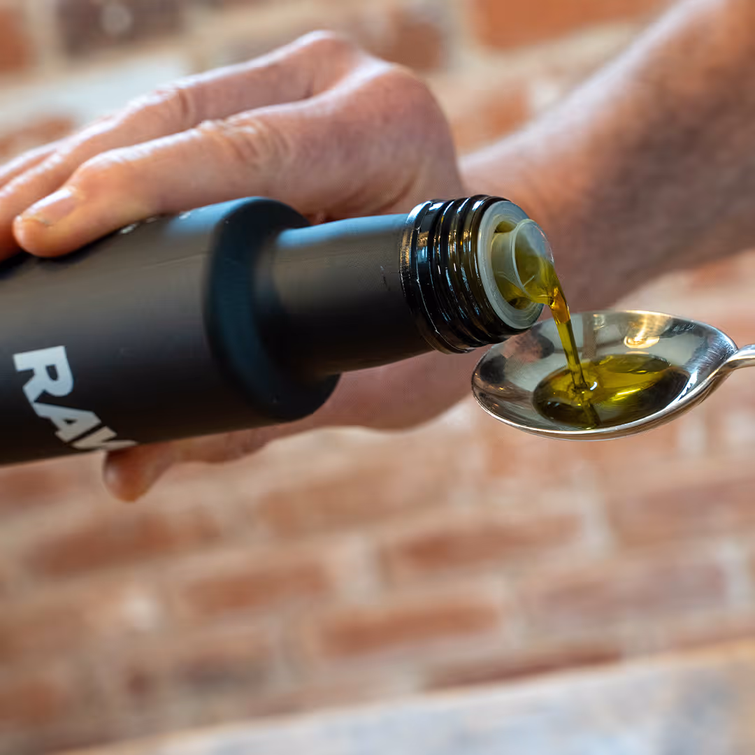 Three black bottles of RAW+ extra virgin olive oil with labels showing 500, 2000, and 1000 polyphenol units.
