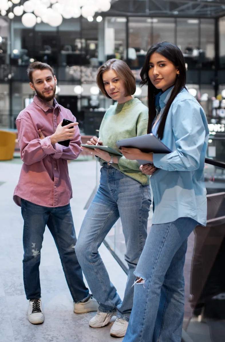 Three people standing and smiling