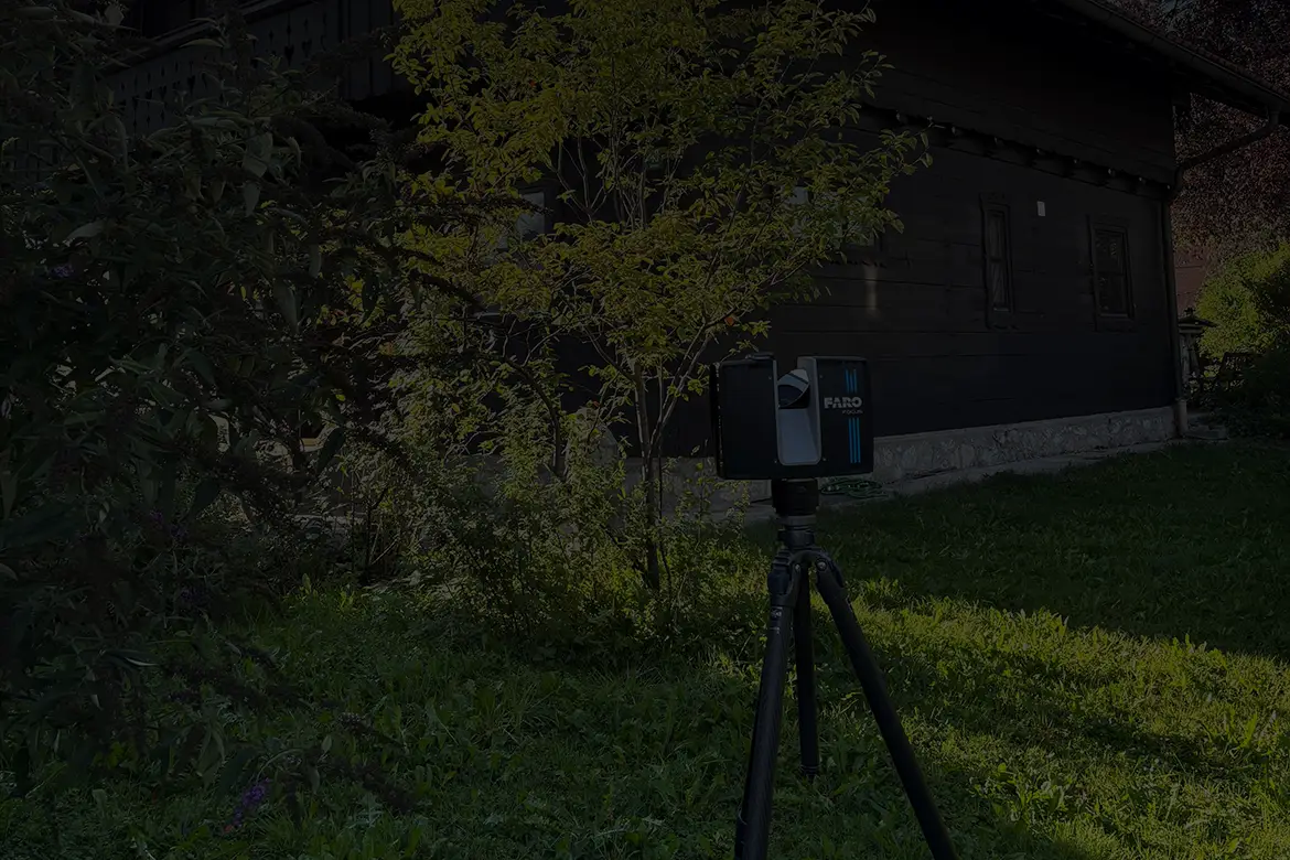 Ein 3D-Laserscanner ist auf einem Stativ im Garten eines Holzhauses positioniert, um Gebäudedaten für eine Bestandsaufnahme zu erfassen.