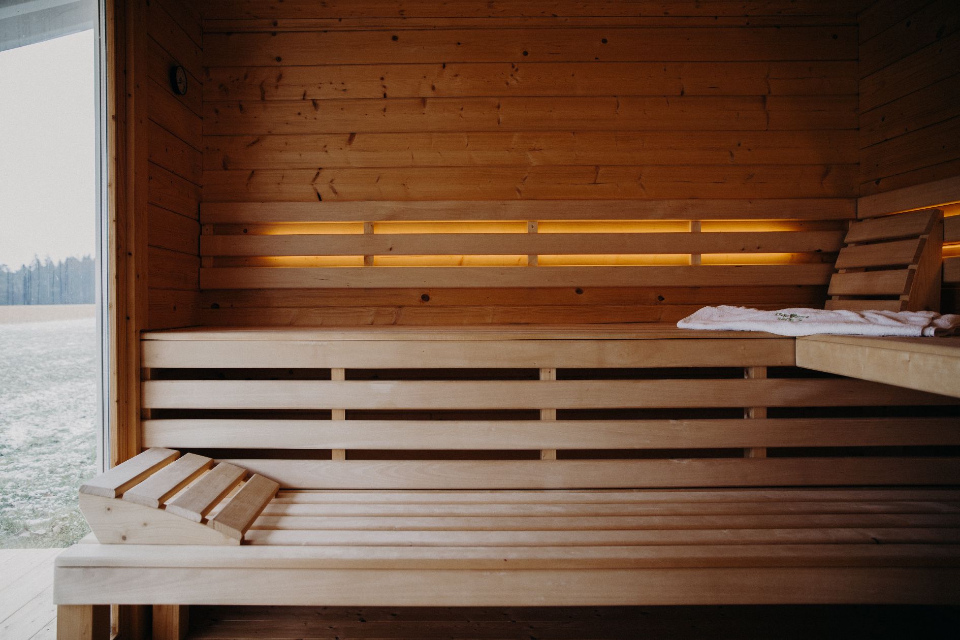 Innenansicht Sauna mit Holzbänken und LED-Beleuchtung.