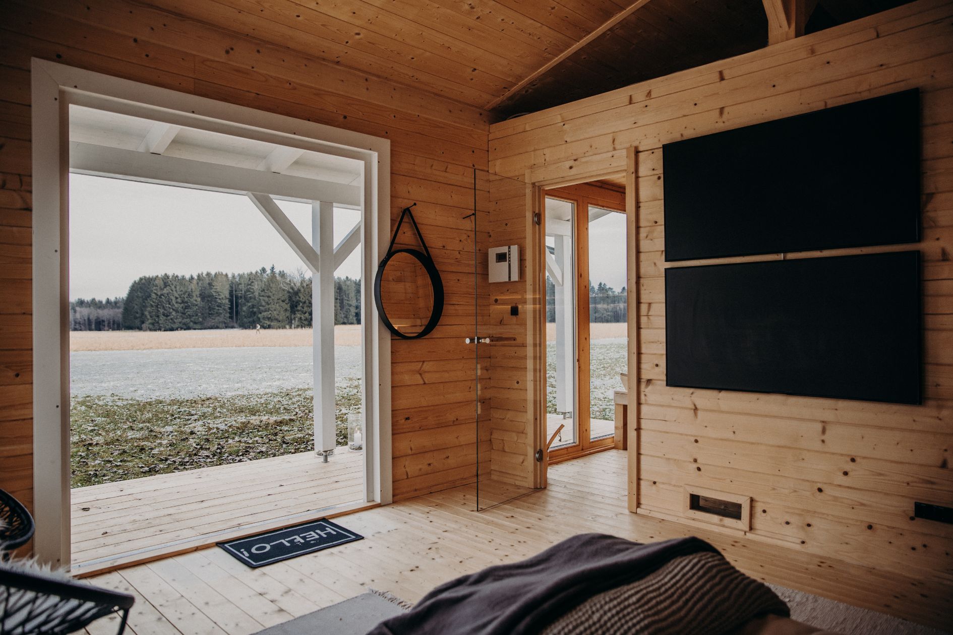 Blick durch Glastür in den Saunaraum mit Panorama-Fenster.