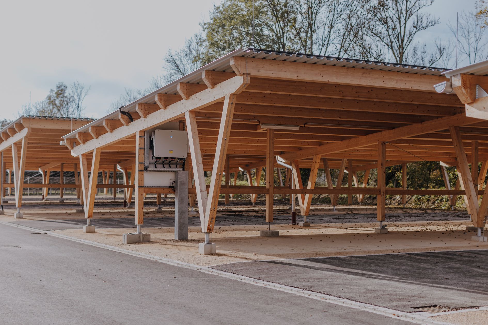 Carportanlage aus Brettschichtholz mit Parkplatzflächen.