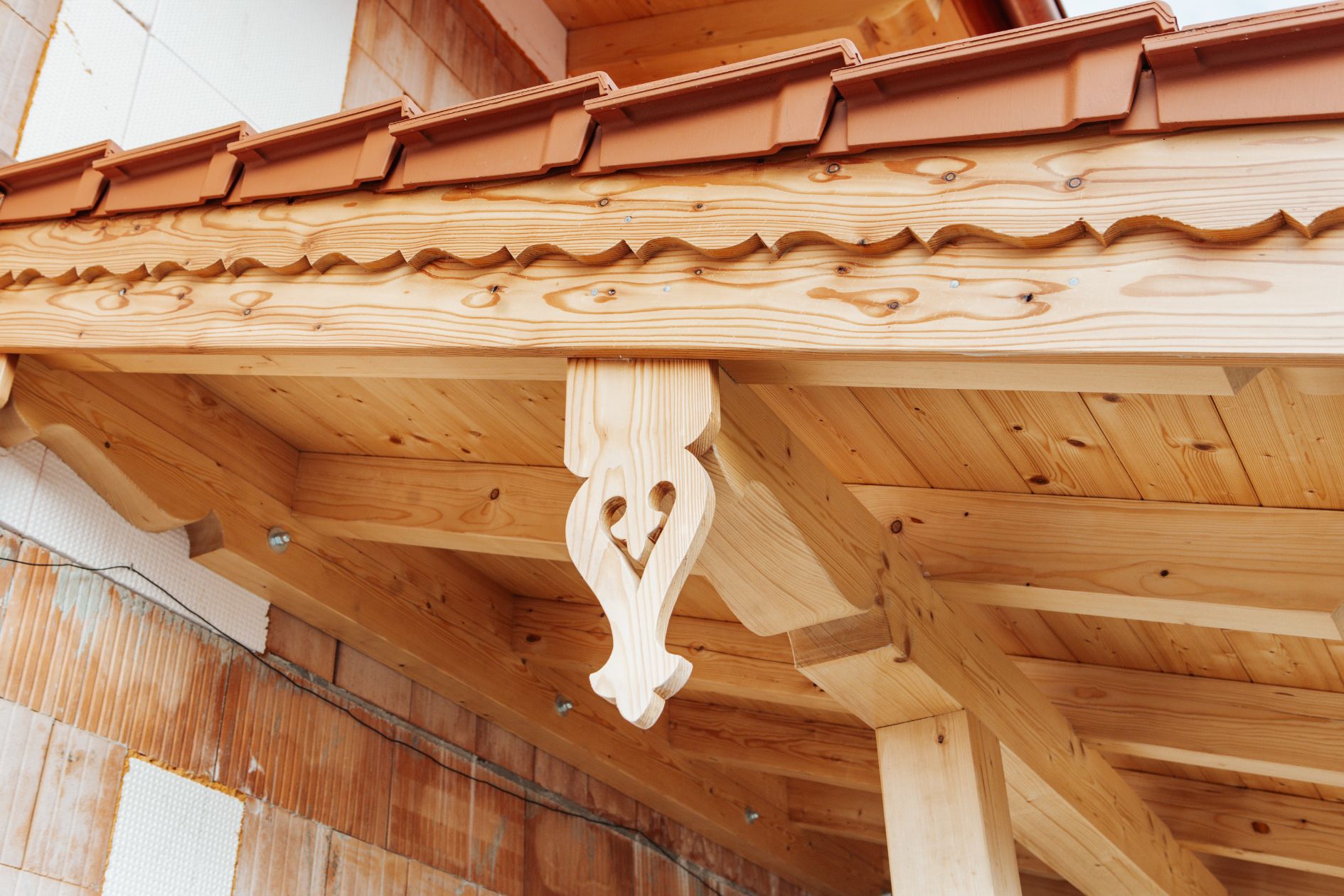 Detailaufnahme der Holzschnitzereien am Windbrett des Vordachs.