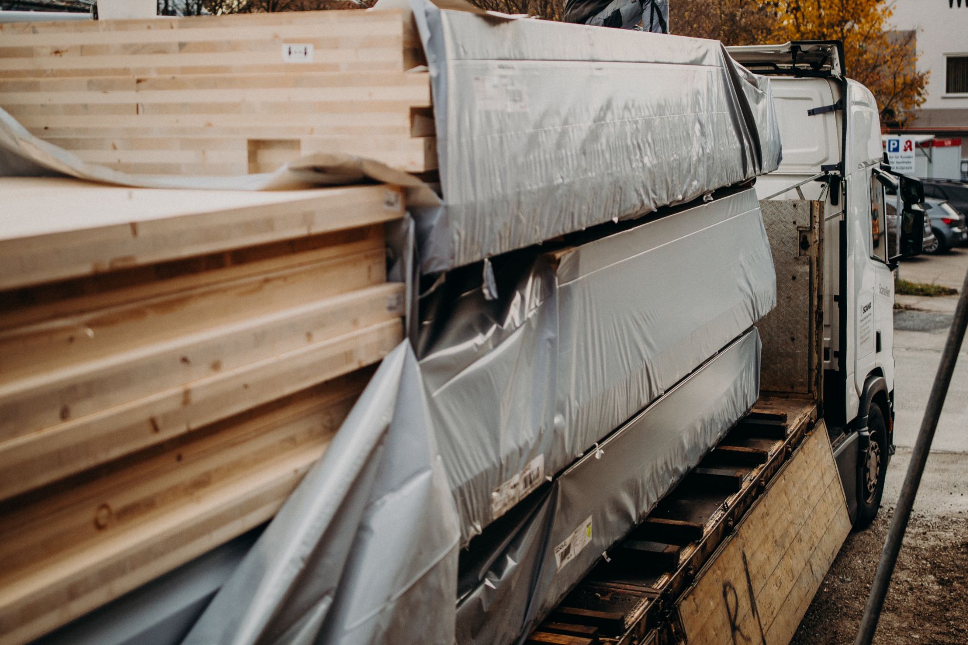 Lkw liefert geschützte Holzbauelemente zur Baustelle an.