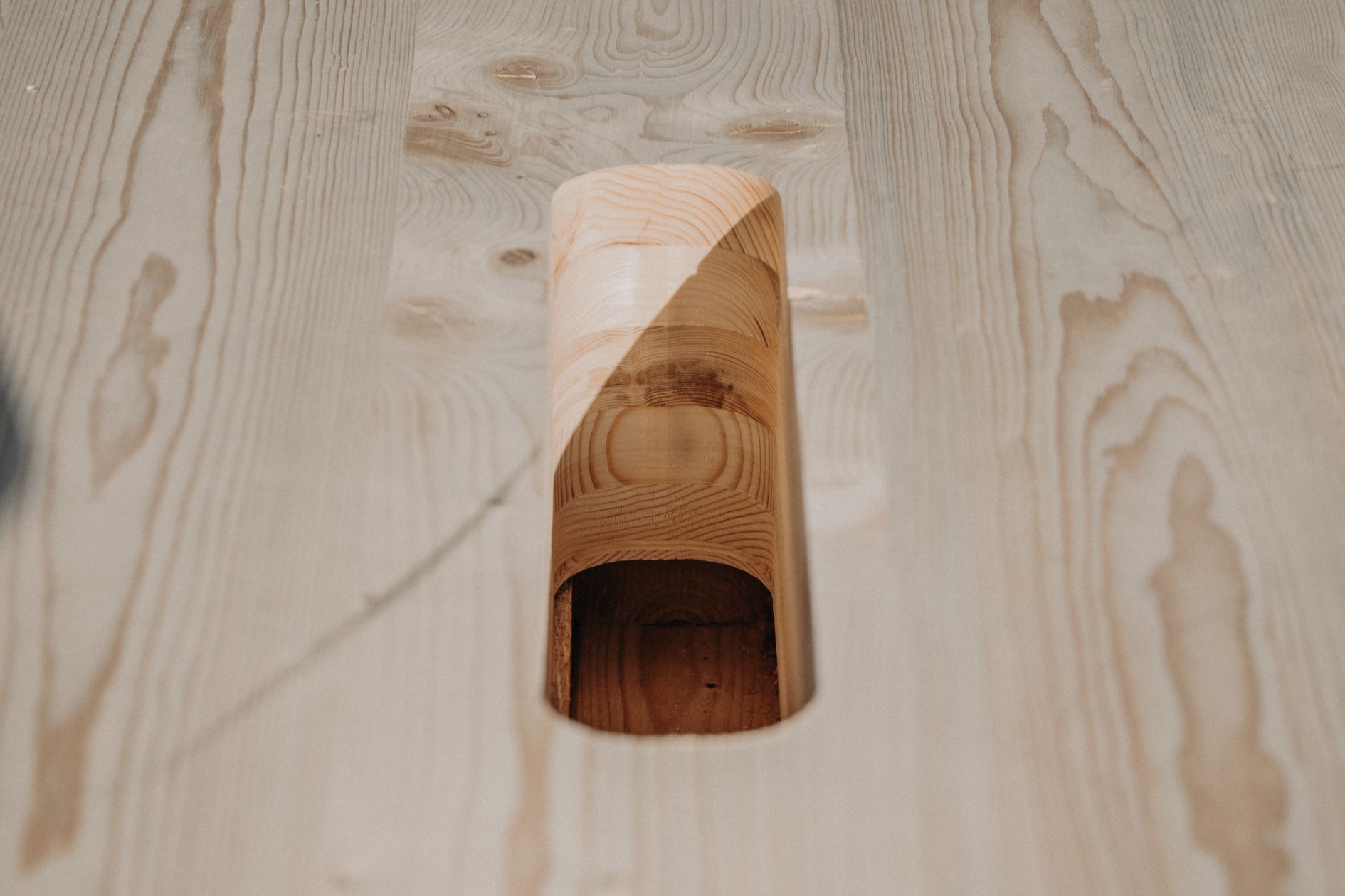 Nahaufnahme einer präzise gefrästen Öffnung in einer massiven Holzdecke für die verdeckte Kranmontage.