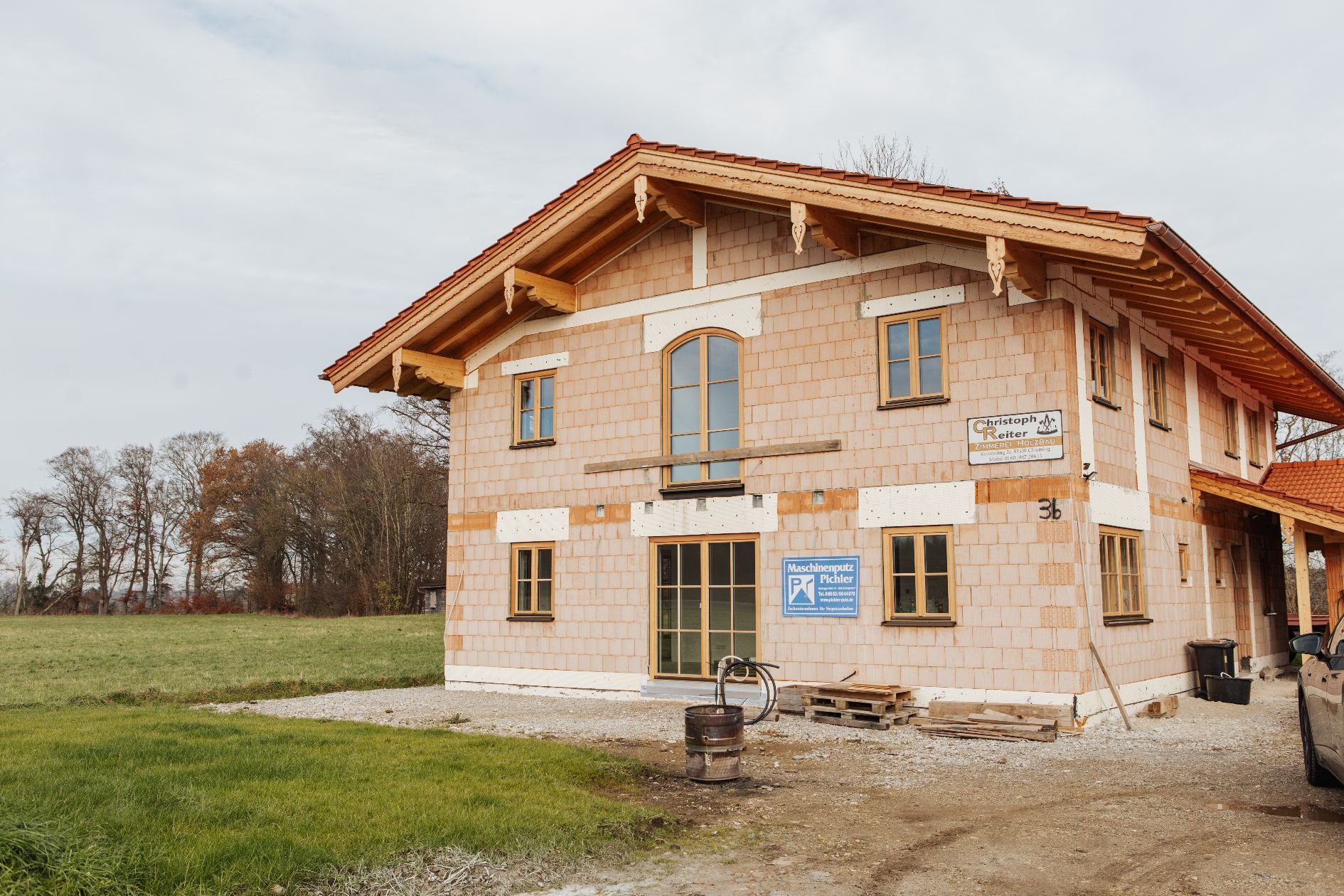 Haus mit kombiniertem modernen Putz und traditionellem Holzvordach.
