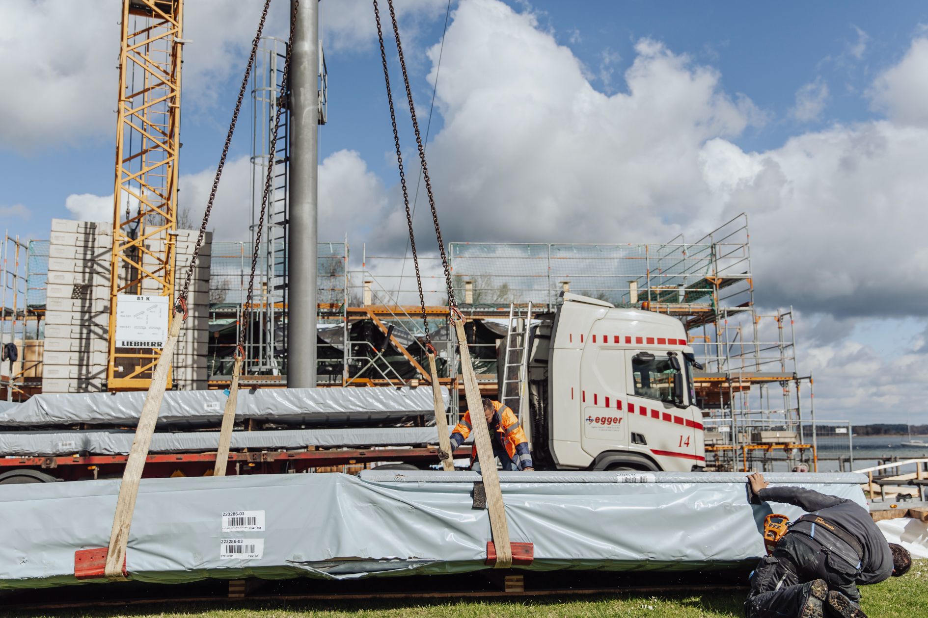 Anlieferung von Holzbauelementen per LKW auf der Baustelle.