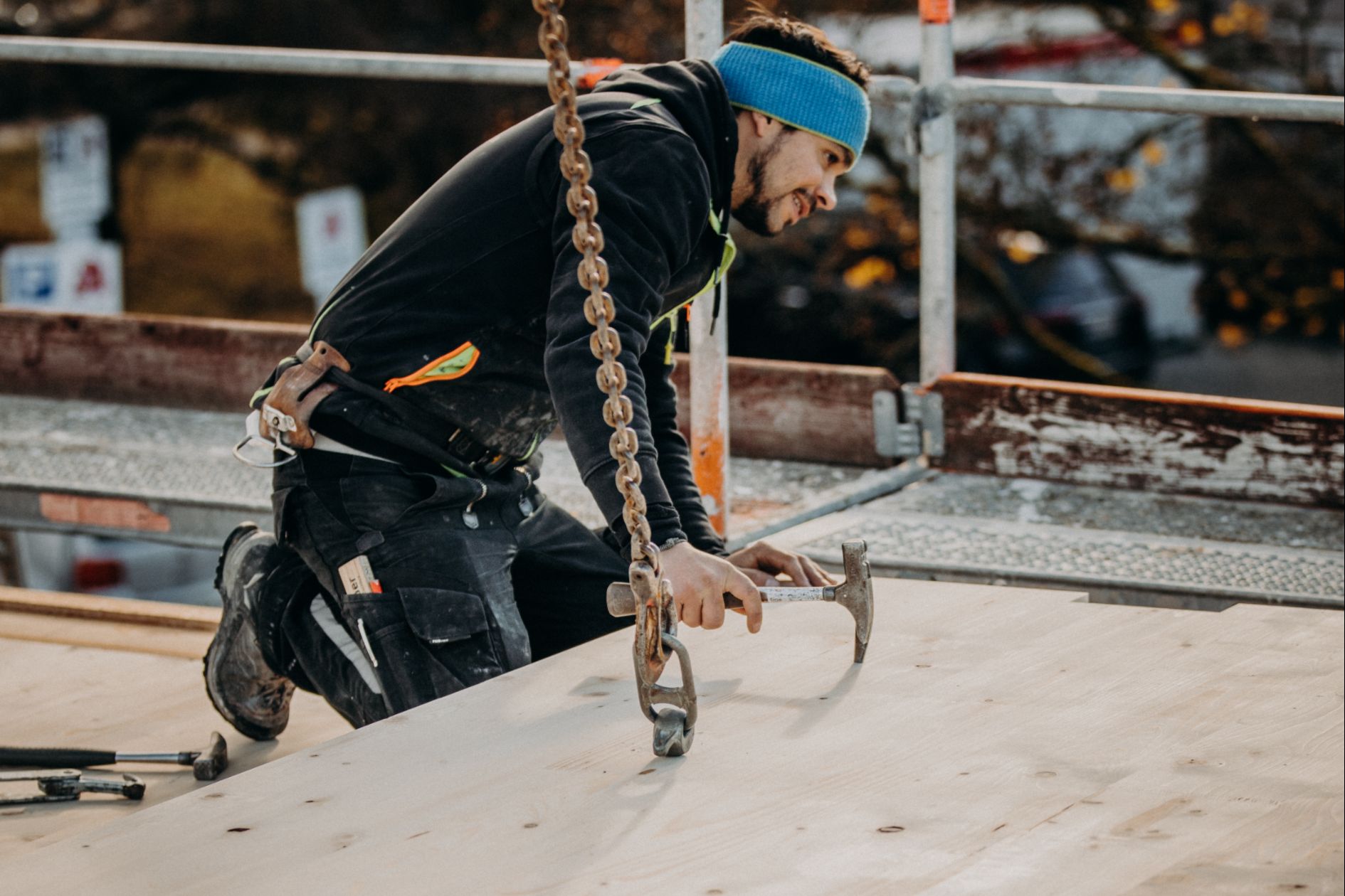 Zimmerer befestigt CLT-Element auf Baustelle.
