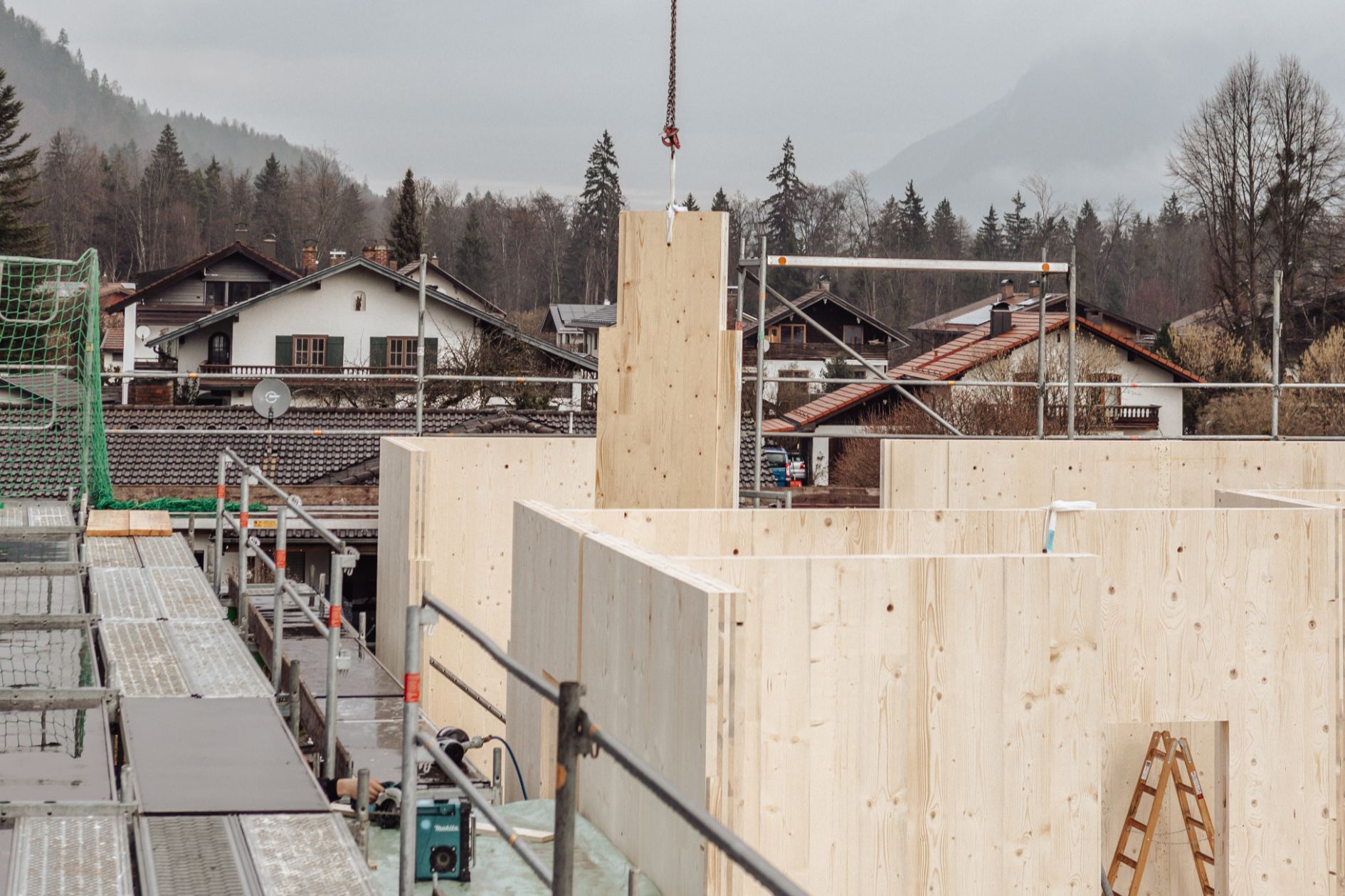 Eine Brettsperrholzplatte wird auf der Baustelle als Wandbauteil eingesetzt.