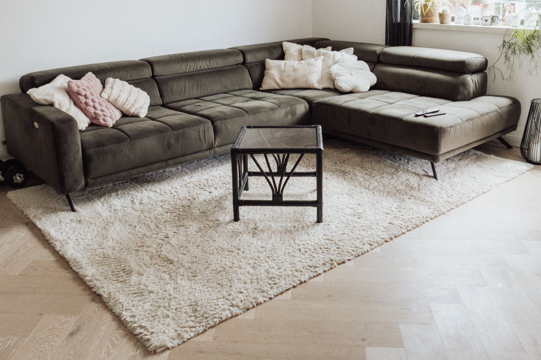 Wohnzimmer mit gemütlicher Couch, Teppich und Eichenboden im Fischgrät.
