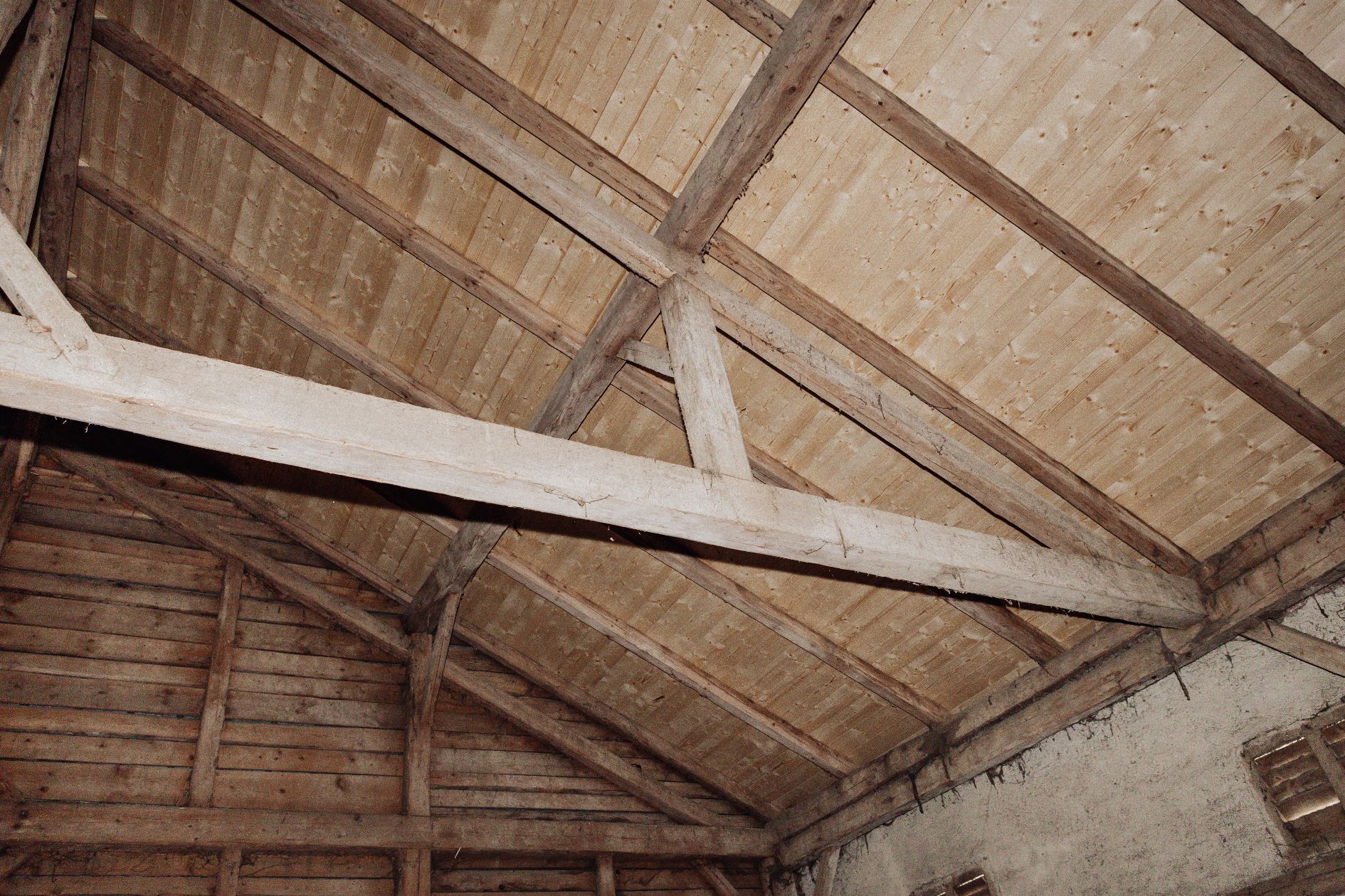 Innenansicht des sanierten Dachstuhls mit neuer Sichtschalung und alten Balken.