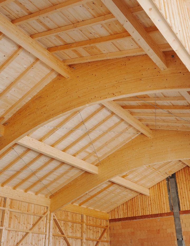 Holzbau mit eindrucksvollen Bogenbindern im Dachstuhl.