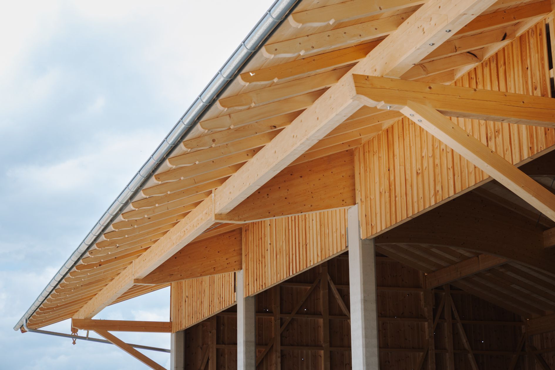 Außenansicht einer modernen Holzhalle mit Dachkonstruktion.