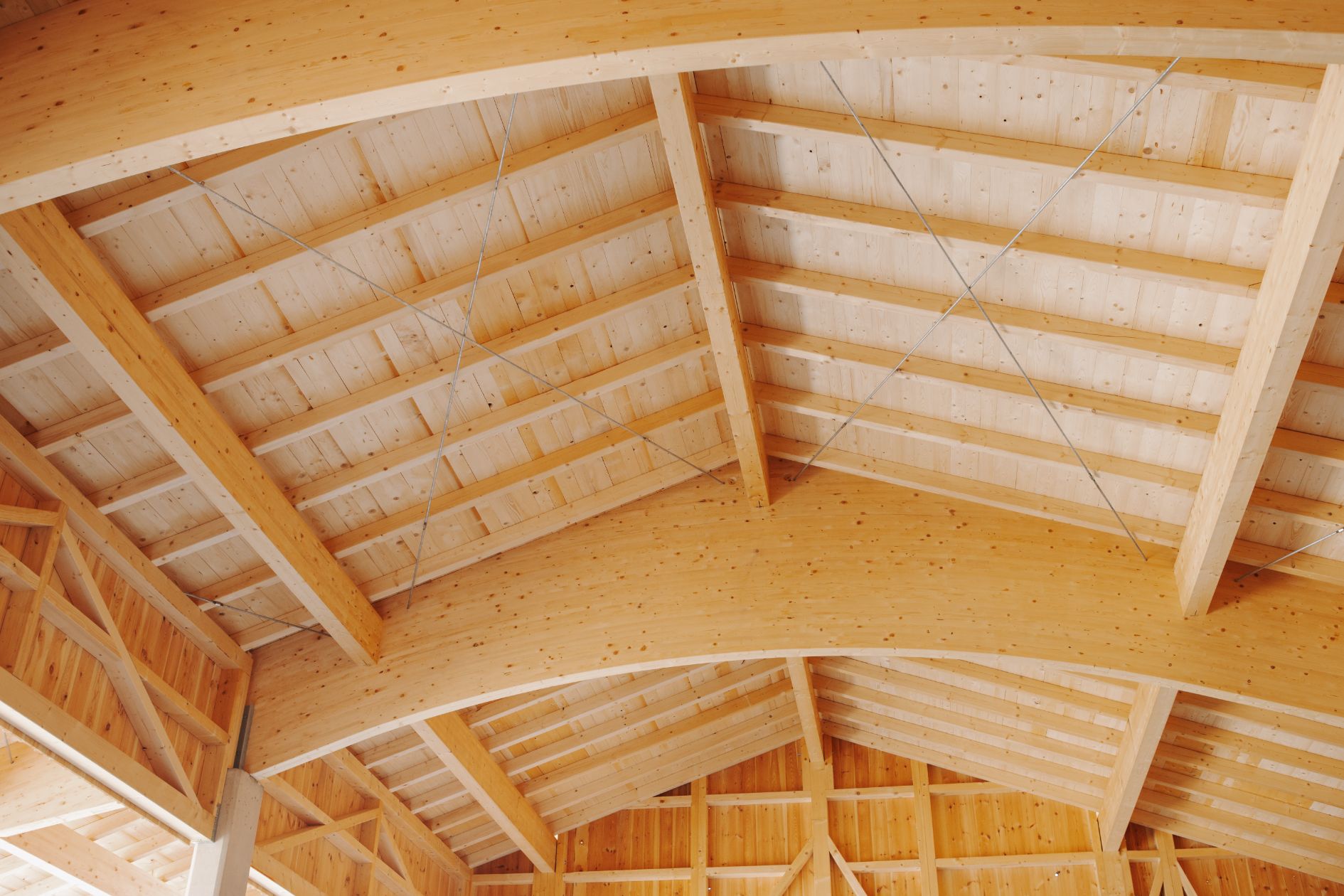 Holzbau mit eindrucksvollen Bogenbindern im Dachstuhl.