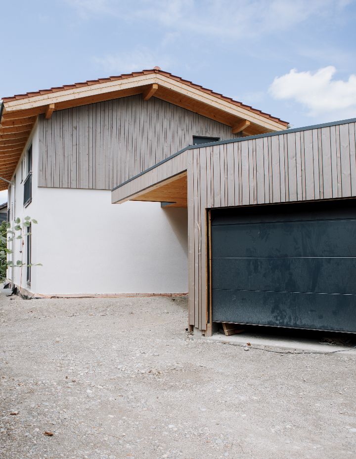 Modernes Wohnhaus mit Holzfassade und angebauter Garage.
