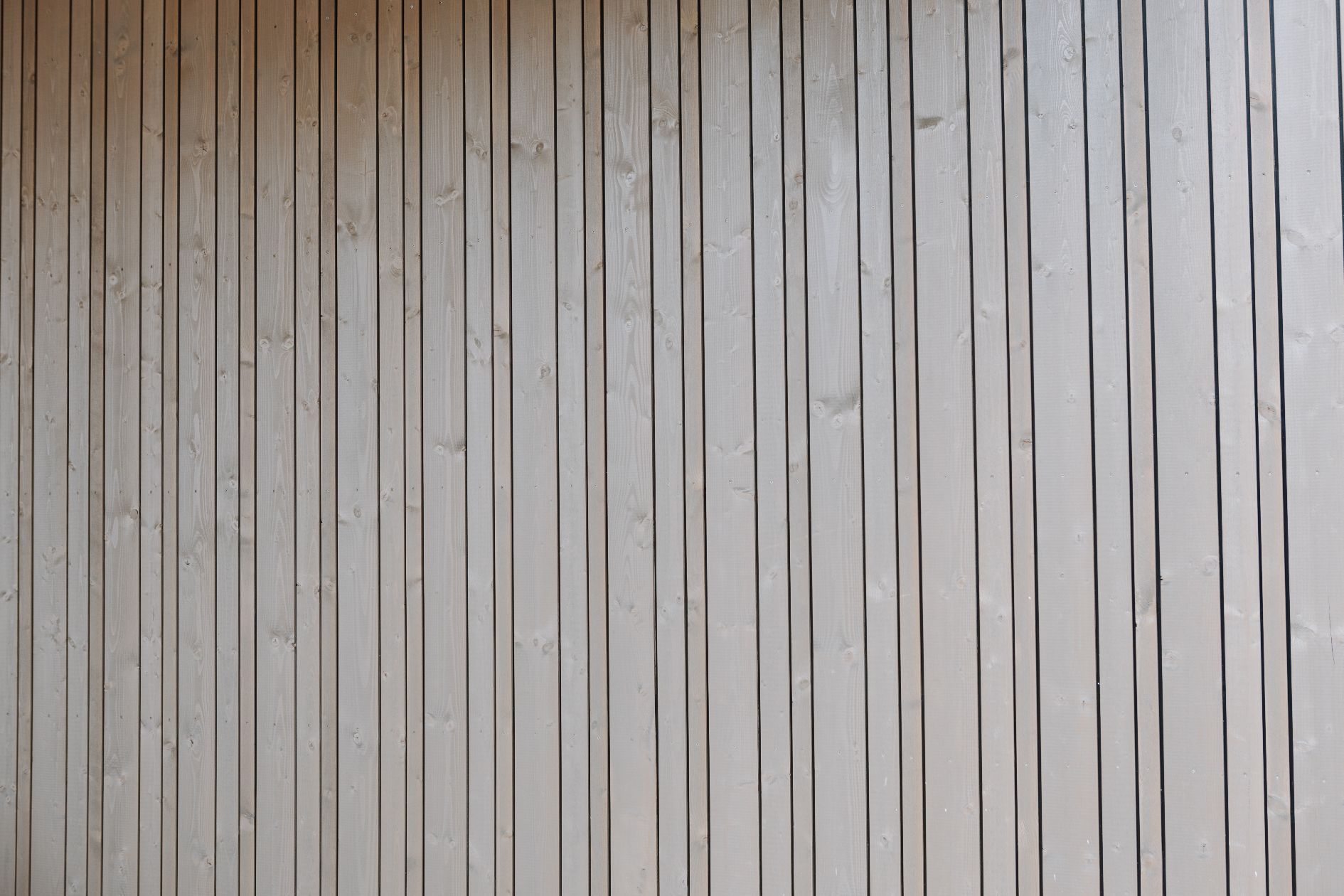 Vertikale Holzfassade in Grau.