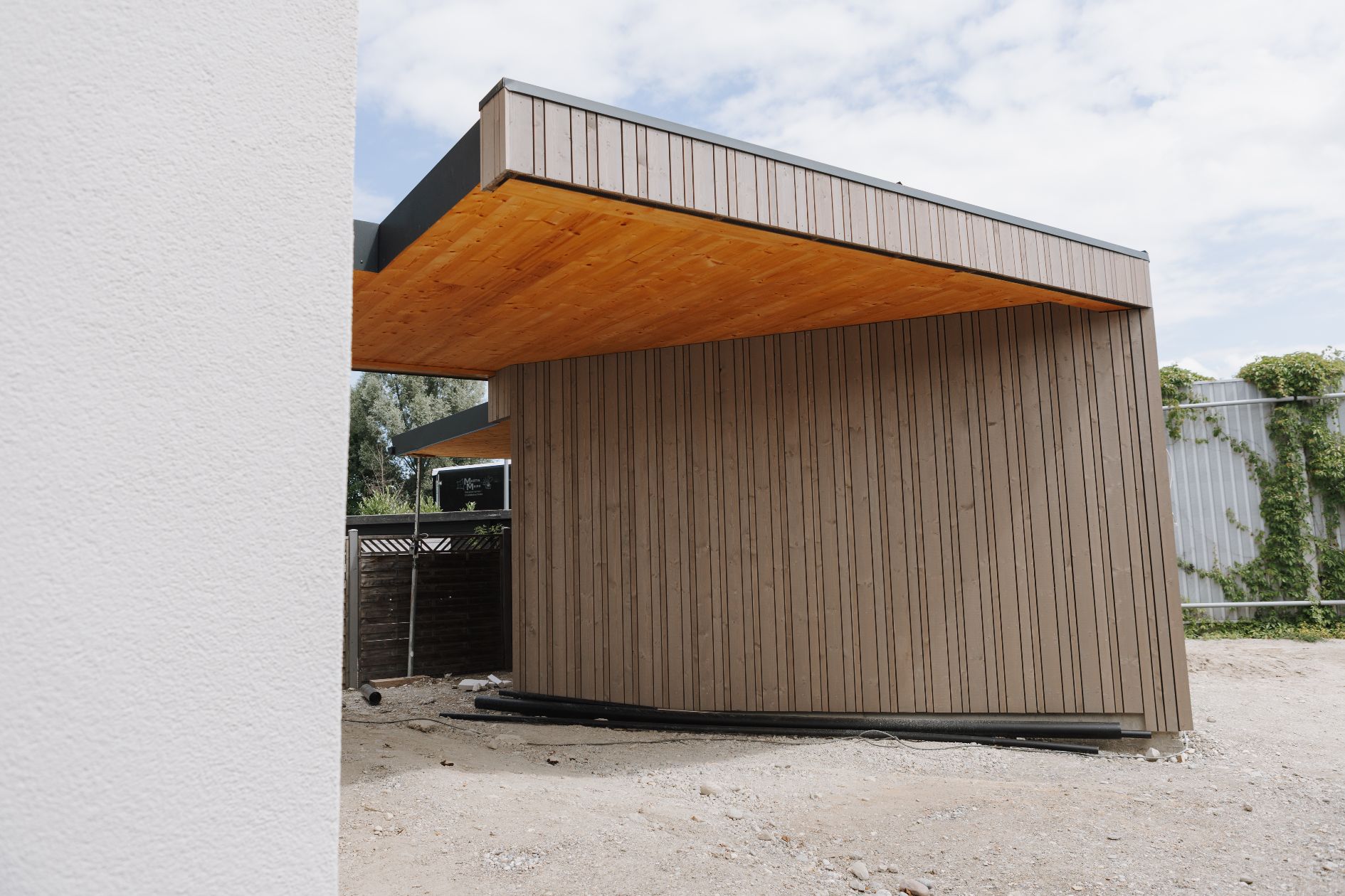 Seitenansicht Carport mit Holzfassade.