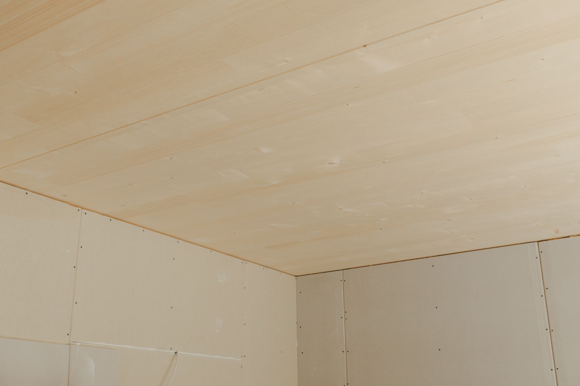 Detail Holzdecke und Trockenbauwand.