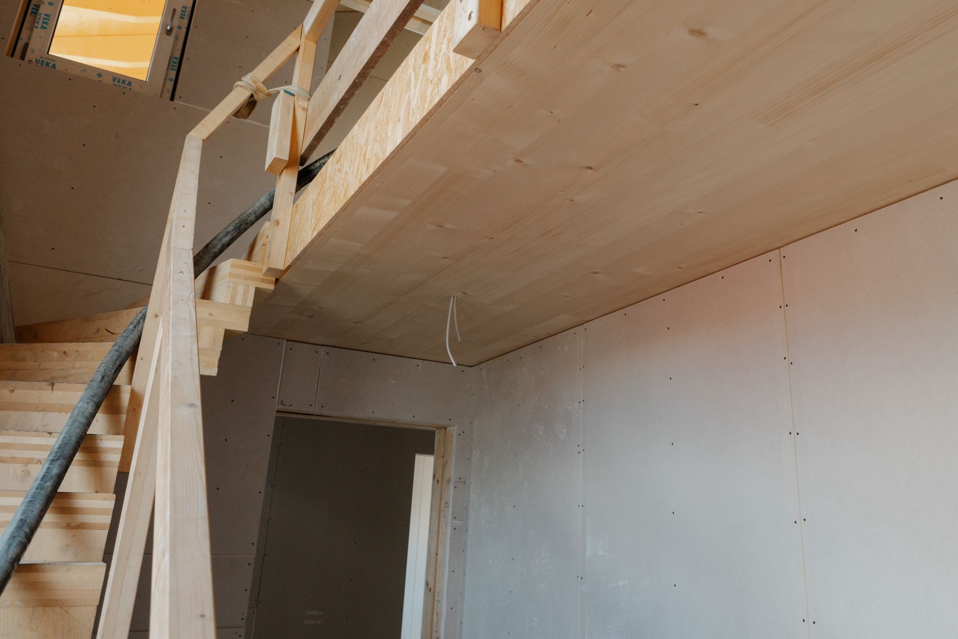 Treppenaufgang mit Holzdecke und Galerie.