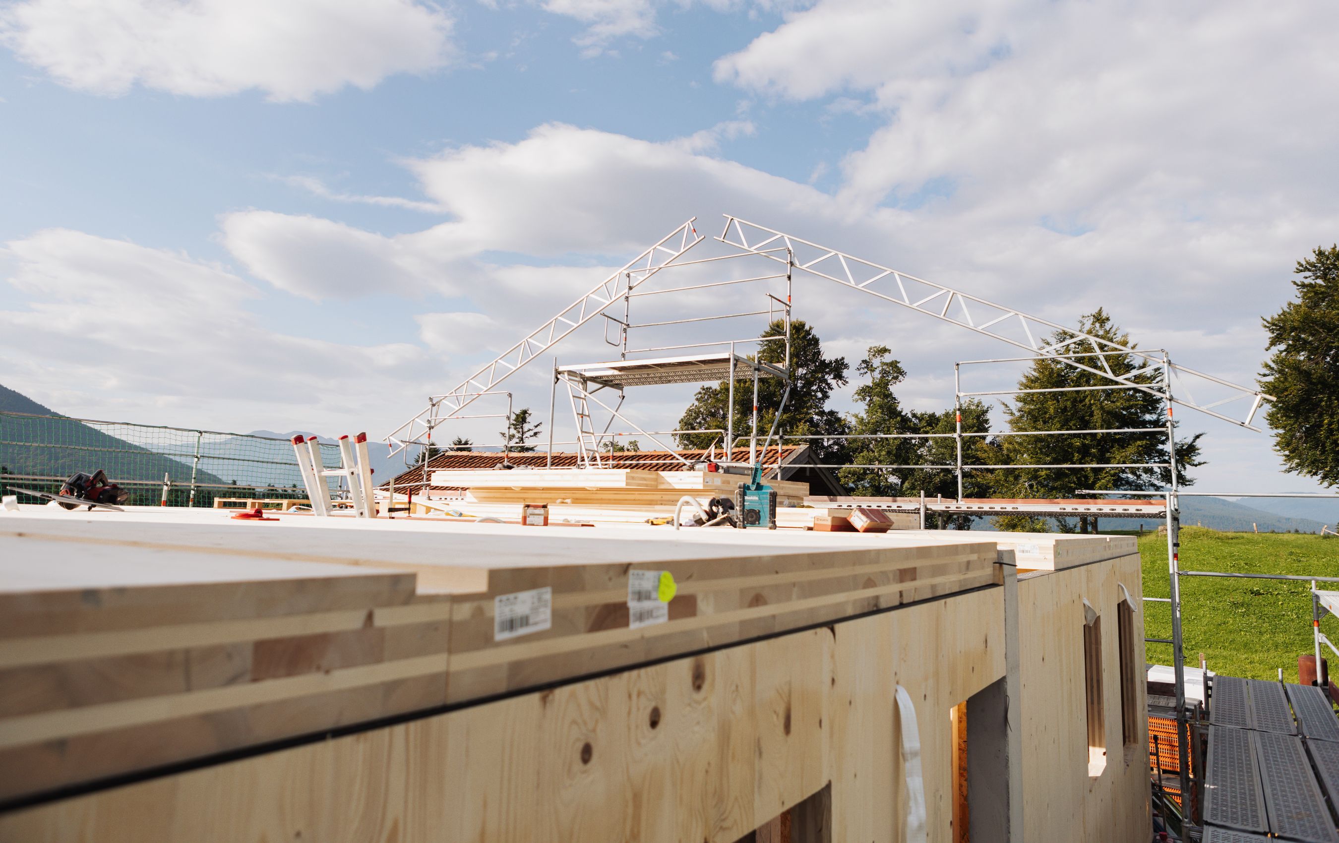 Blick auf eine Baustelle mit montierten Holzwänden und Holzbalken,